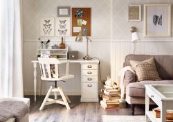 A corner in the living room with a white desk and a swivel chair.