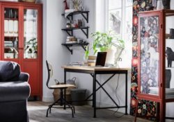 Industrial style desk and swivel chair in pine/black in a living room with red/brown.